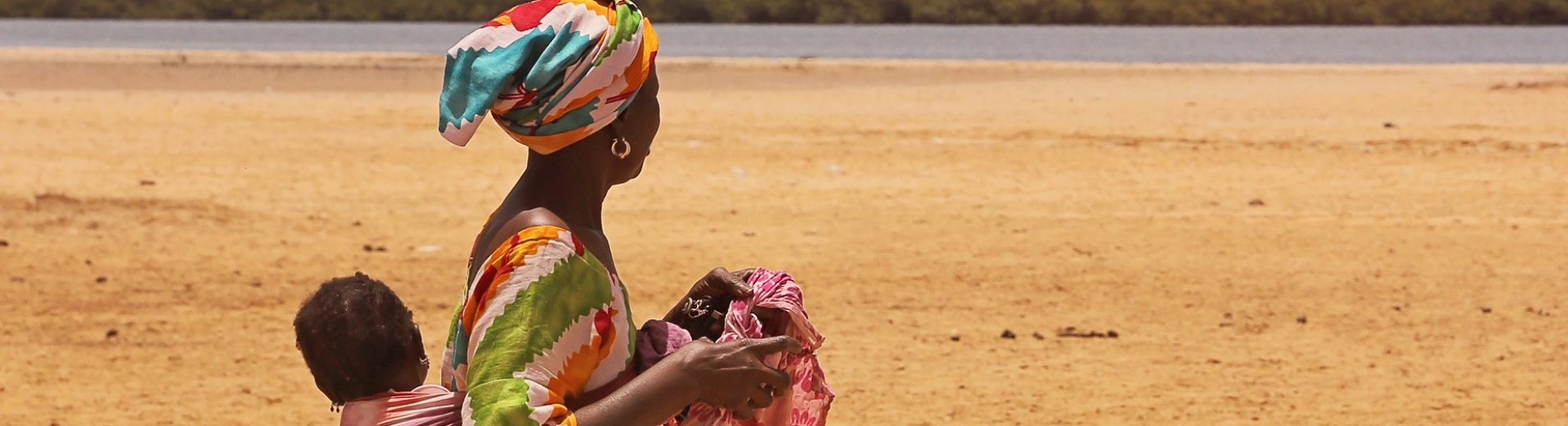 sénégalaise en boubou avec son bébé dans le dos