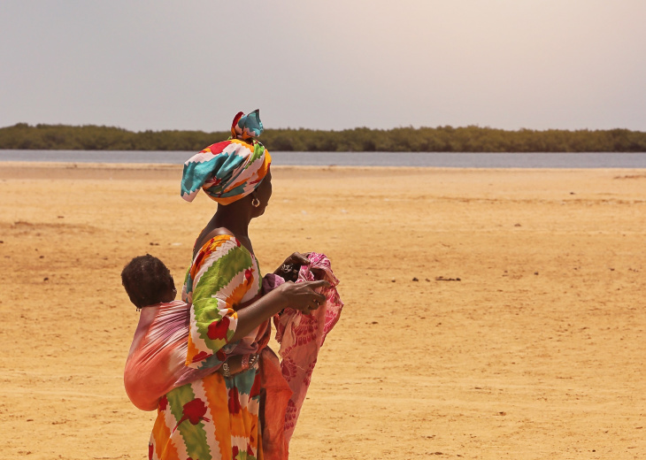 sénégalaise en boubou avec son bébé dans le dos