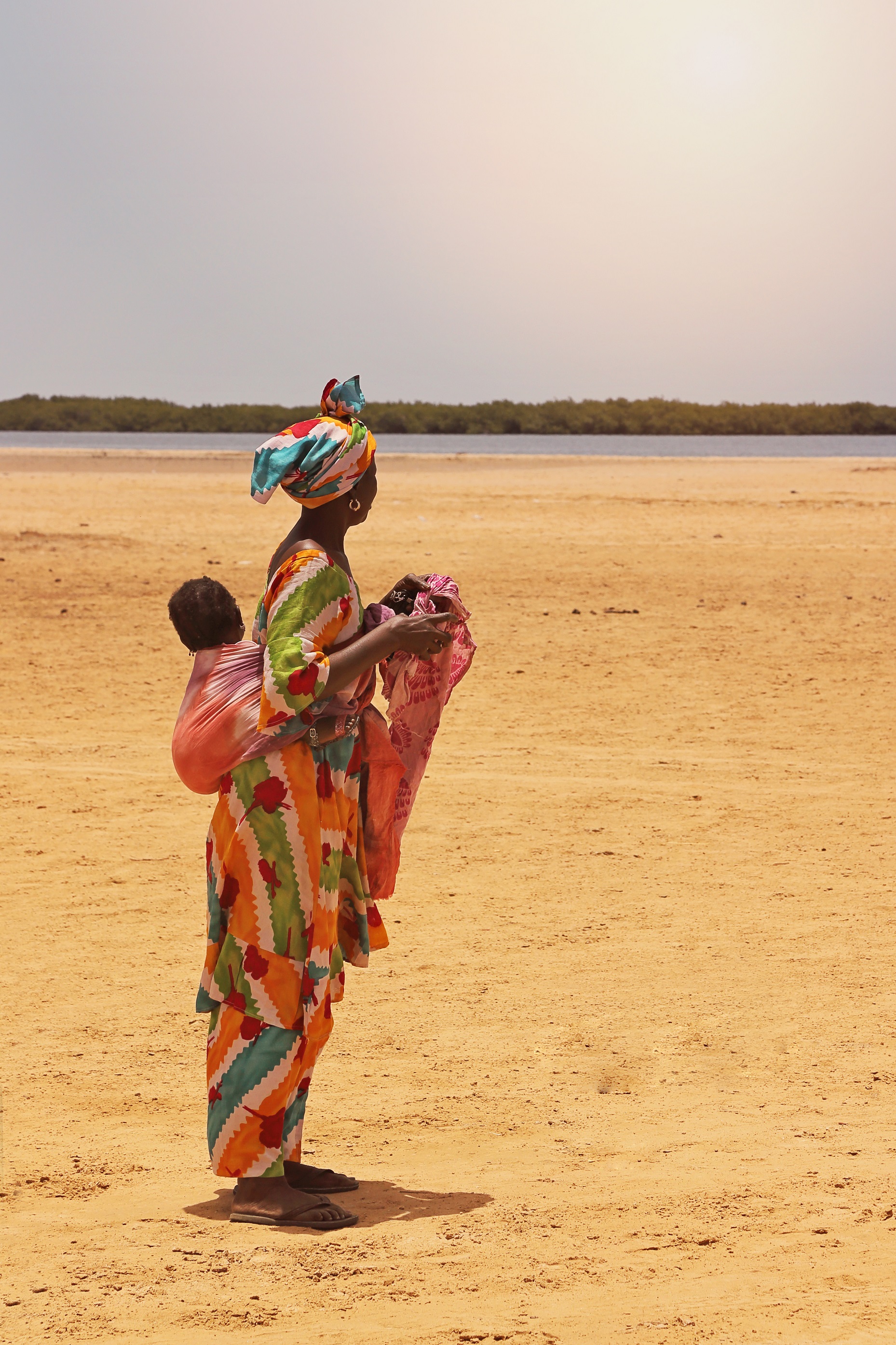 sénégalaise en boubou avec son bébé dans le dos