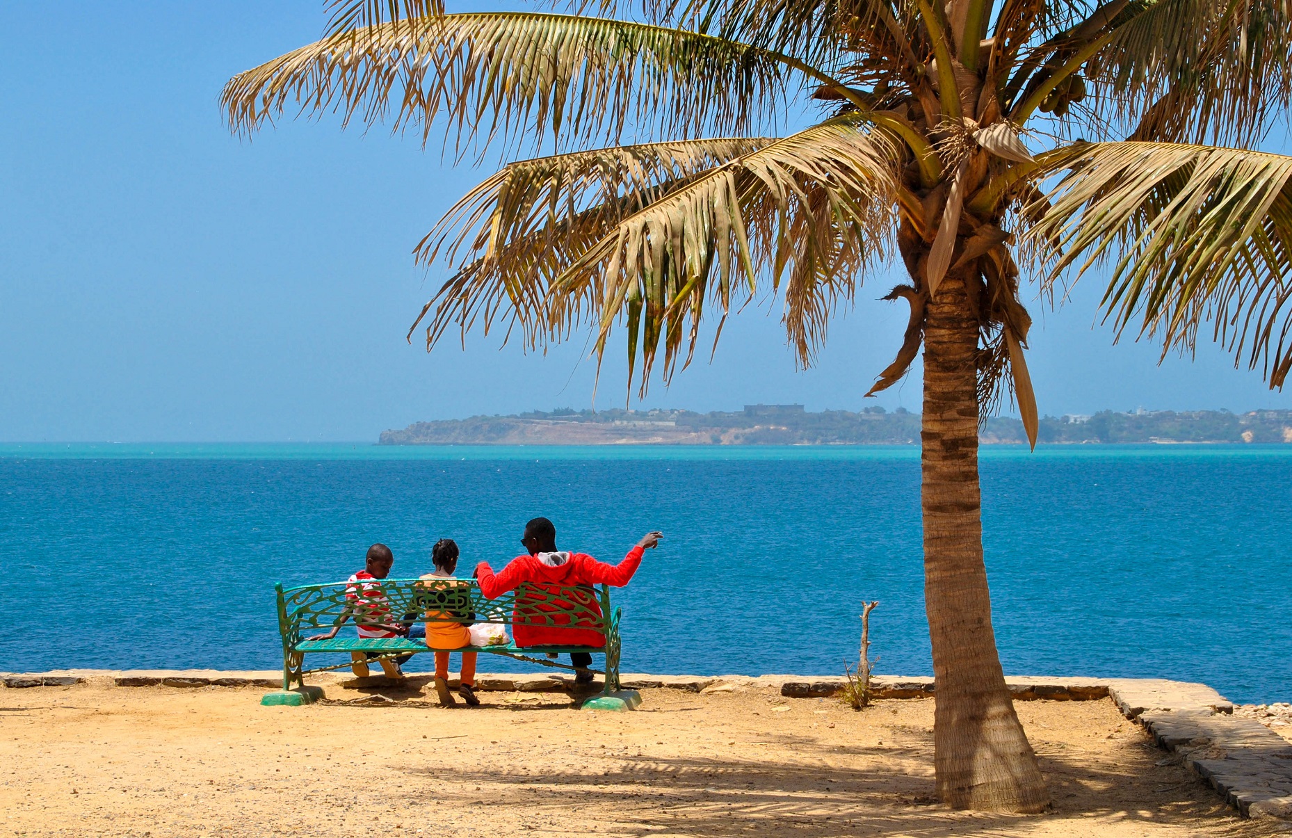 Personnes sur un banc face à la mer sur l'île de Gorée