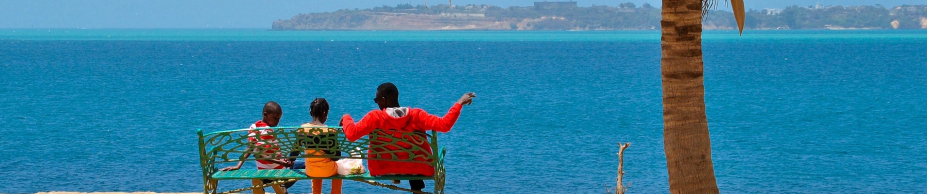 Sénégalais avec ses deux enfants sur un banc sur l'île de Gorée