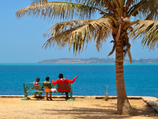 Sénégalais avec ses deux enfants sur un banc sur l'île de Gorée