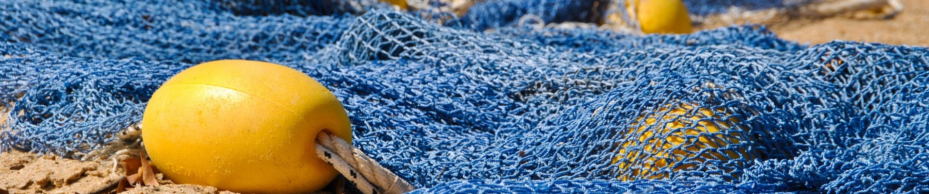 filets de mer bleu avec boules jaune sur le sable au Sénégal