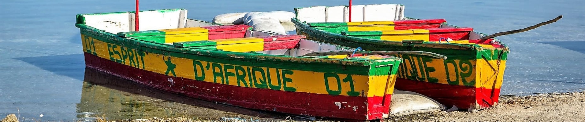 Deux pirogues sur le Lac Rose aux couleurs du Sénégal et avec deux drapeaux du pays